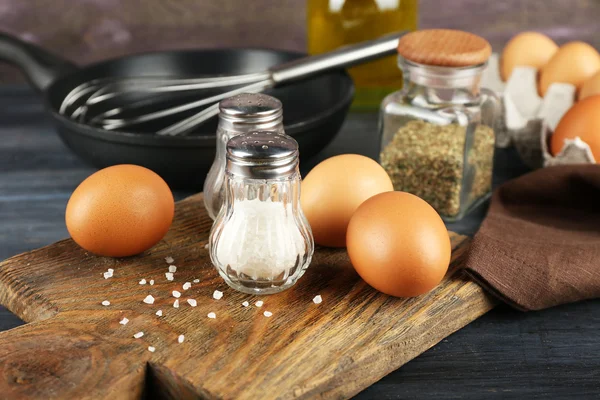 Bodegón con huevos y sartén sobre fondo de madera —  Fotos de Stock