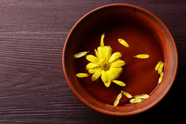 Blomma kronblad i skål, närbild, på träbord bakgrund — Stockfoto