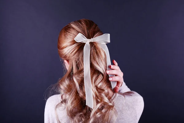 Penteado feminino com fita de cor no fundo escuro — Fotografia de Stock