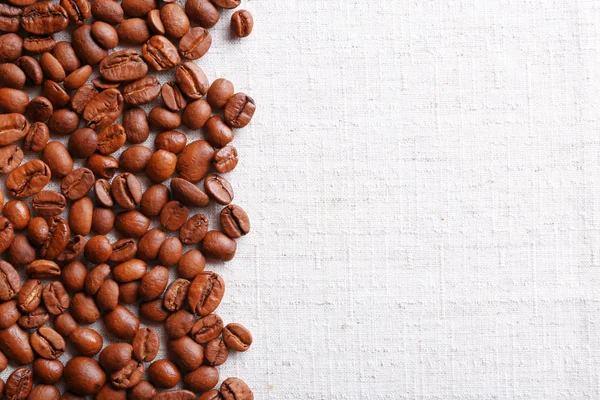 Frame of coffee beans on color sackcloth background — Stock Photo, Image