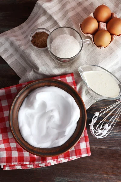 Schlageiweiß und andere Zutaten für Sahne auf Holztisch, Draufsicht — Stockfoto