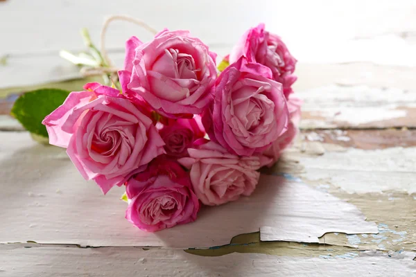 Krásné čerstvé růže na staré dřevěné pozadí — Stock fotografie