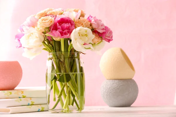 Buquê de rosas frescas e tulipas em vaso de vidro sobre fundo rosa — Fotografia de Stock