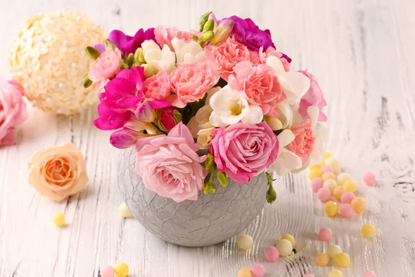 Beautiful fresh spring flowers in pot on wooden table, closeup — Stock Photo, Image