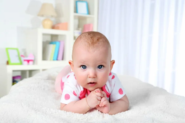 Schattige babymeisje, op huis interieur achtergrond — Stockfoto