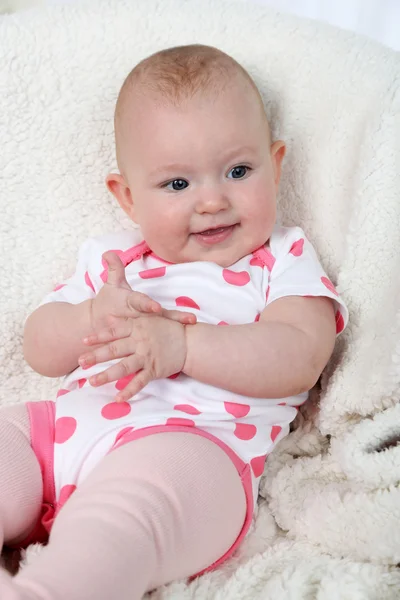 Cute baby girl sitting in arm-chair, on home interior background — Stock Photo, Image