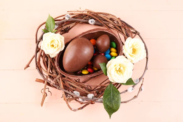 Ovos de Páscoa de chocolate com flores em ninho de vime, close-up — Fotografia de Stock