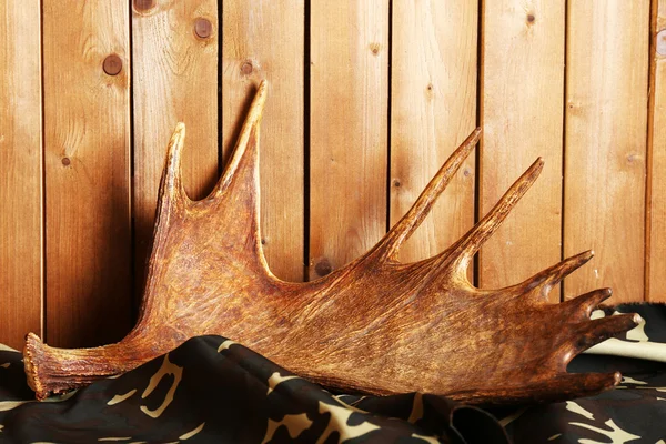 Moose antler on fabric on wooden background — Stock Photo, Image