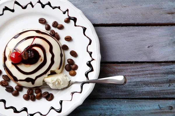 Välsmakande panna cotta dessert på plattan, träbord — Stockfoto