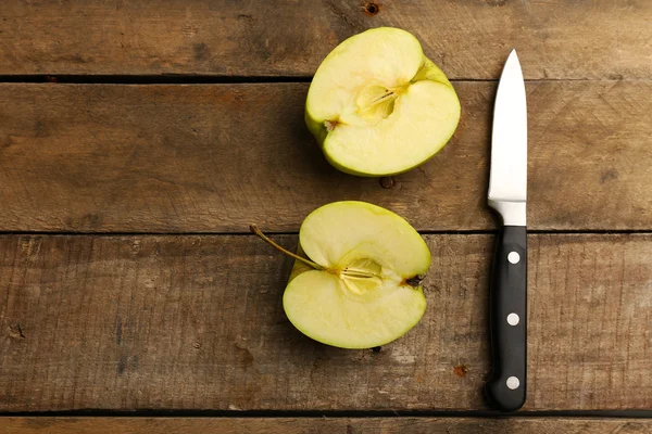 Geschnittener Apfel mit Messer auf Holzgrund — Stockfoto