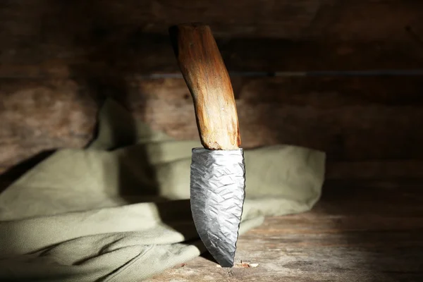 Hunting knife and sackcloth on wooden background — Stock Photo, Image