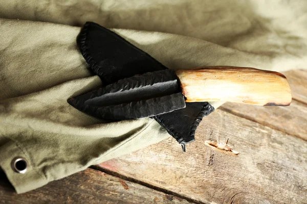 Hunting knife and sackcloth on wooden background — Stock Photo, Image