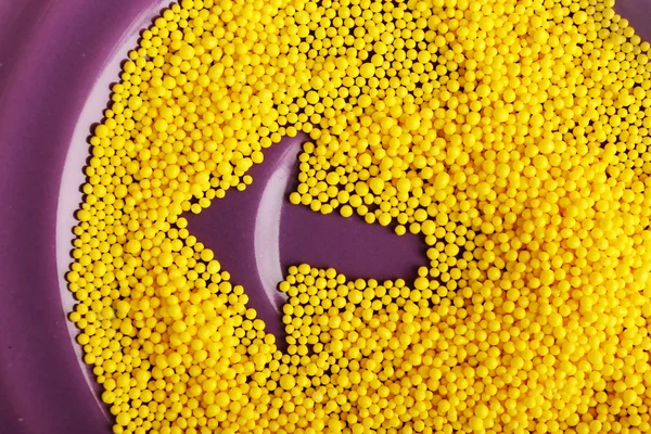 Arrow on purple plate with color beads, closeup — Stock Photo, Image