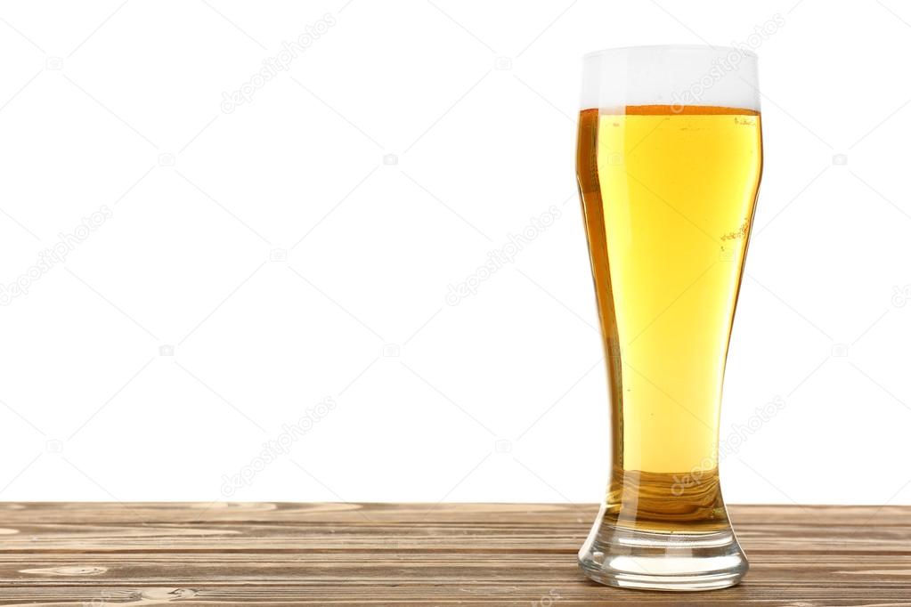 Glass of beer on wooden table, isolated on white