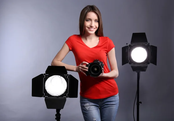 Joven fotógrafa tomando fotos sobre fondo gris —  Fotos de Stock