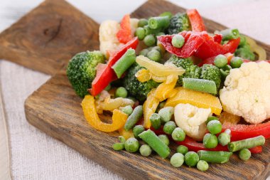 Peçeteye ahşap masa arka plan üzerinde kesme tahtası üzerinde Dondurulmuş sebzeler