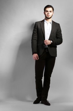 gri arka plan üzerinde takım elbiseli şık adam