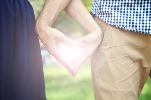 Liefdevol paar bedrijf handen in de vorm van hart, close-up — Stockfoto