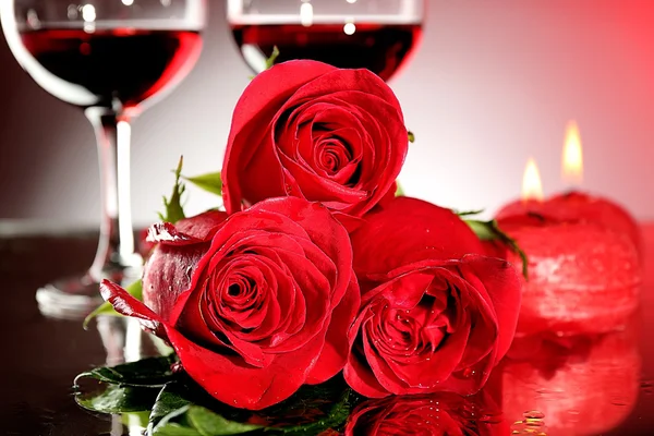 Σύνθεση με κόκκινο κρασί σε ποτήρια, κόκκινο τριαντάφυλλο και διακοσμητικά καρδιά σε πολύχρωμα φόντο — Φωτογραφία Αρχείου