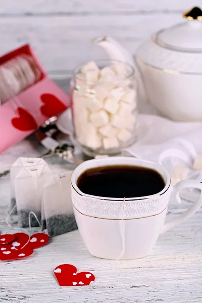 Tazza da tè a forma di cuore tag, scatola e tazzina da tè su sfondo di legno — Foto Stock