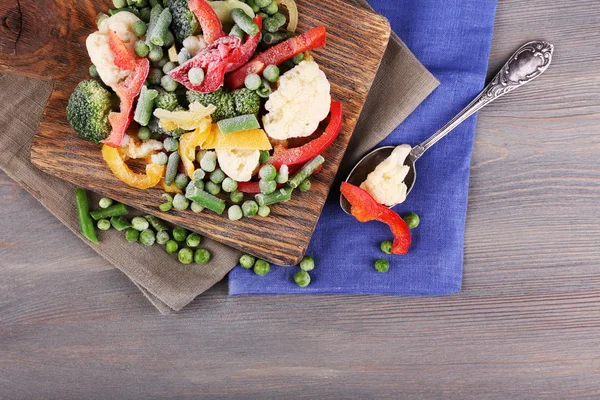 在砧板上餐巾，木桌背景上的冷冻的蔬菜 — 图库照片
