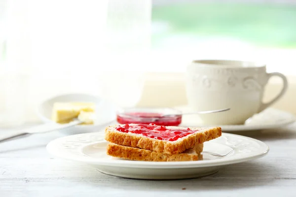 明るい背景で紅茶のカップとプレートのジャムとトースト — ストック写真