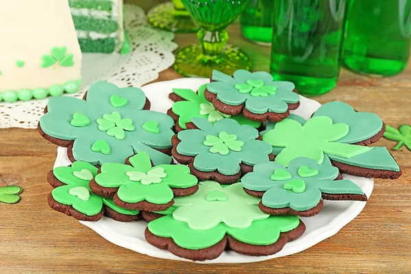 Νεκρή φύση με φέτες κέικ, μπισκότα και πράσινη beer για Saint Patrick ΠΡΩΤΟΧΡΟΝΙΑ σε ξύλινο τραπέζι φόντο — Φωτογραφία Αρχείου