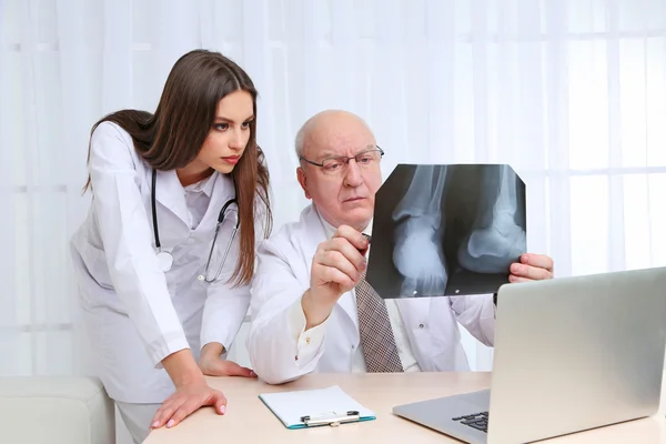 Médecins recevant des résultats de rayons X au bureau sur fond blanc — Photo