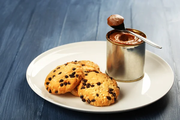 Can of boiled condensed milk with spoon and cookies — Stock Photo, Image