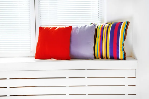 Colorful pillows on windowsill — Stock Photo, Image