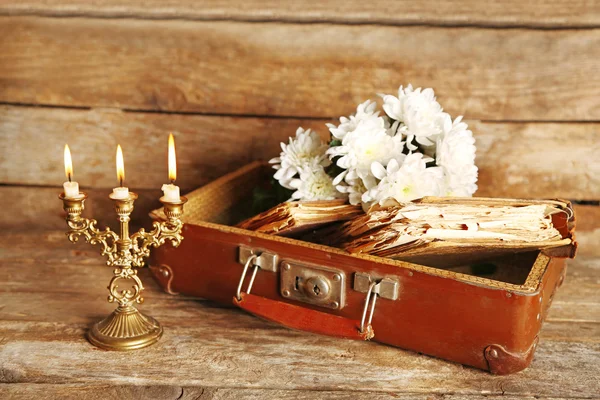 Eski kitaplar ve çiçeklerle ahşap arka plan üzerinde eski tahta bavul — Stok fotoğraf