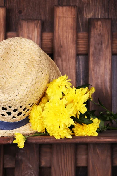 Hut mit Blumen auf Holzgrund — Stockfoto