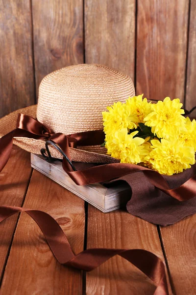 Hut mit Blumen auf Holzgrund — Stockfoto