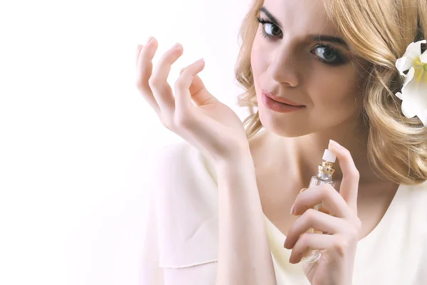 Mooie jonge vrouw met parfumfles op witte isoleren — Stockfoto