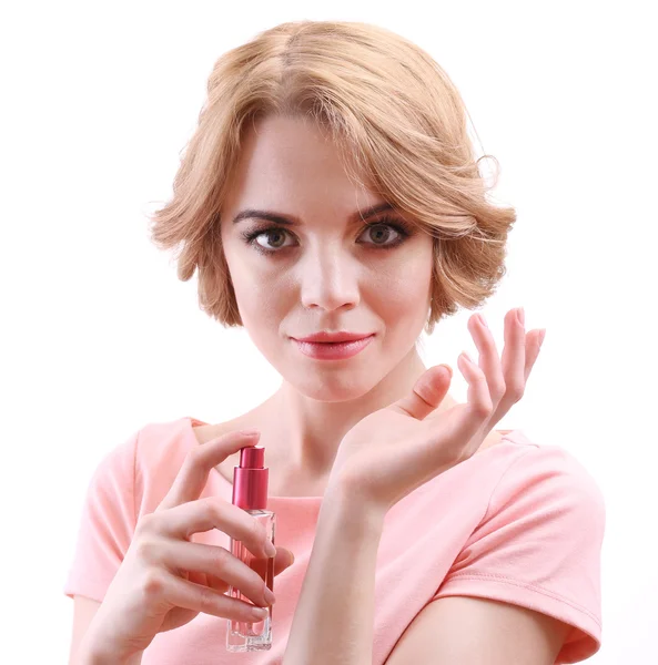 Hermosa joven con botella de perfume aislado en blanco — Foto de Stock