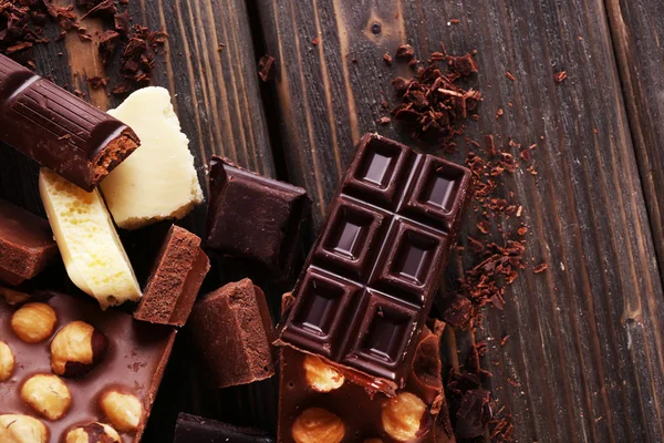 Set of chocolate with hazelnut on wooden table, closeup — Stock Photo, Image