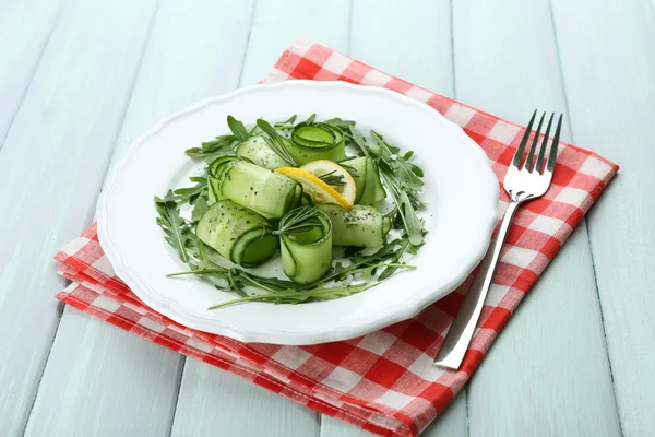 Salatalık, roka ve biberiye ahşap zemin üzerine yeşil salata tabak — Stok fotoğraf