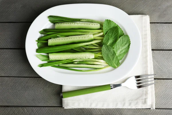 Grüner Salat mit Gurken und Lauch auf Holztisch, Draufsicht — Stockfoto