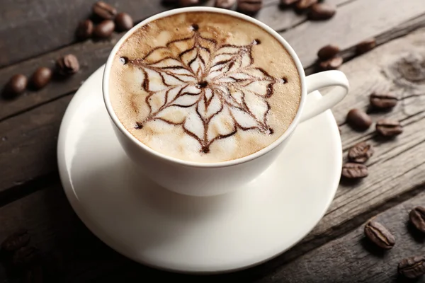 Cup of latte art coffee with grains — Stock Photo, Image