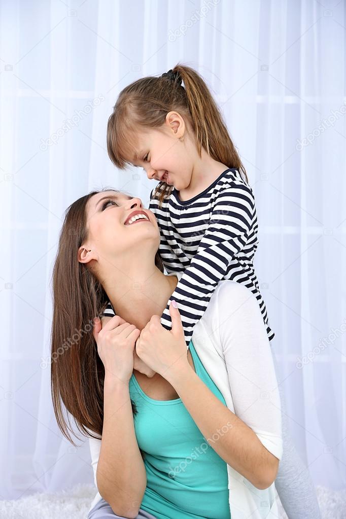 Two girls smiling on light background