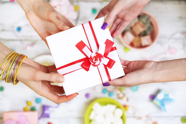 Vrouwelijke handen met cadeau — Stockfoto