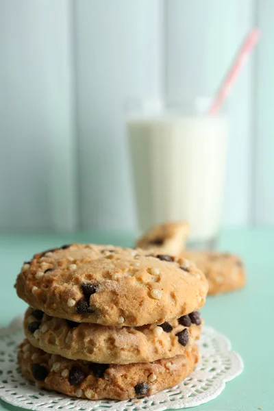 Sabrosas galletas y vaso de leche sobre fondo de madera de color — Foto de Stock