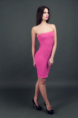 Koyu gri arka plan üzerinde Turuncu elbiseli güzel genç kadın