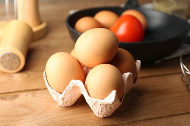 Yumurta ve ahşap masa, closeup tava ile natürmort