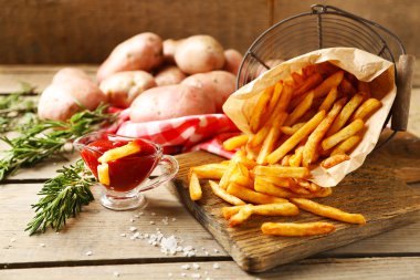 Tahtada patates kızartması, ahşap masa arkasında.