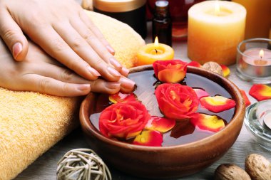 Ahşap masa, closeup aroma spa su kase ile eller