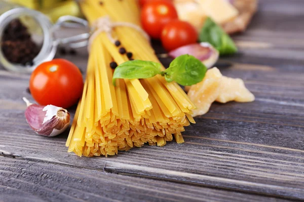 Pâtes crues au fromage et légumes sur fond de bois — Photo