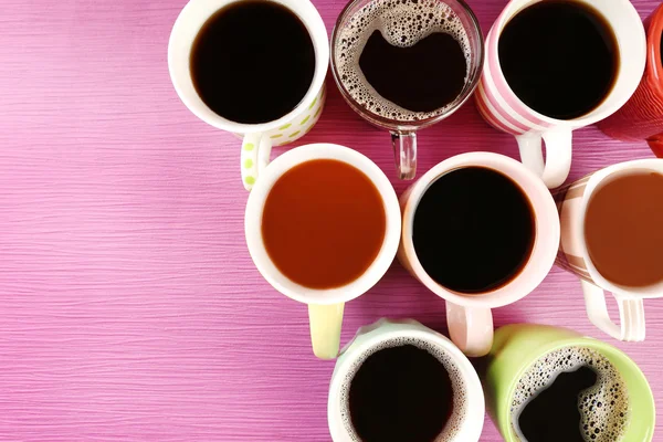 Muchas tazas de café sobre fondo rosa — Foto de Stock