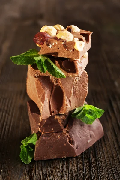 Montón de chocolate con nueces en la mesa de madera, primer plano — Foto de Stock