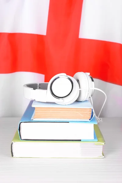 Boeken en koptelefoon op Engeland vlag achtergrond — Stockfoto